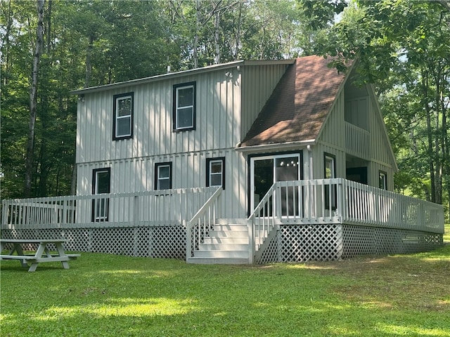 rear view of house featuring a lawn and a wooden deck