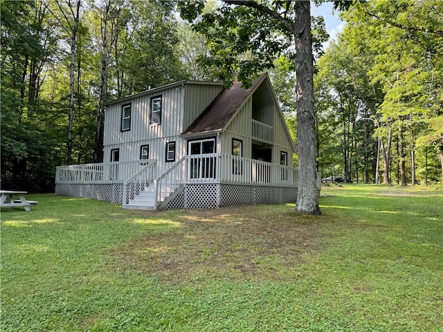 rear view of property with a yard and a wooden deck