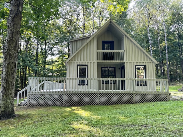 back of house with a wooden deck and a yard