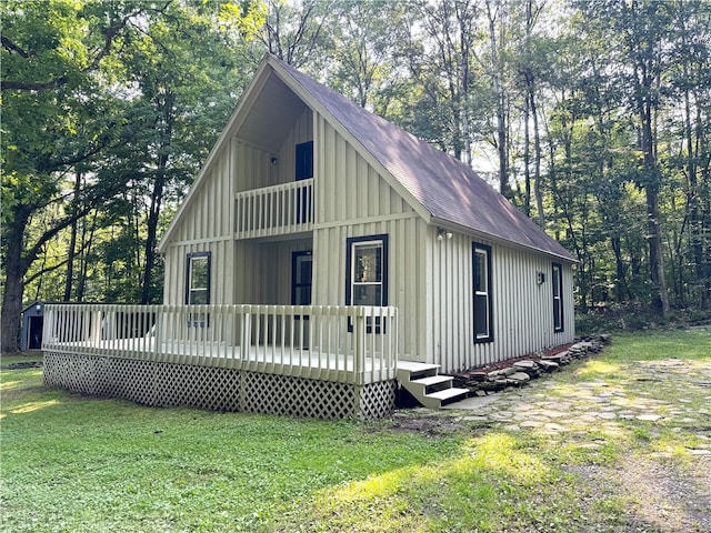 view of front of home with a balcony, a front lawn, and a wooden deck