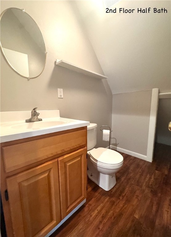 bathroom with vanity, vaulted ceiling, toilet, and hardwood / wood-style floors