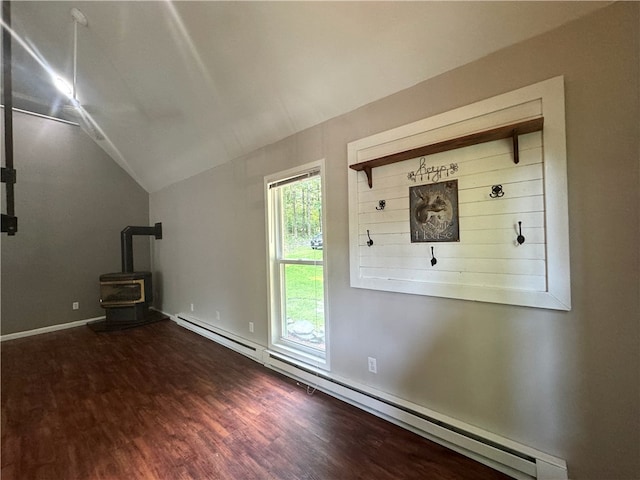 interior space featuring a wood stove, a baseboard heating unit, hardwood / wood-style flooring, and vaulted ceiling