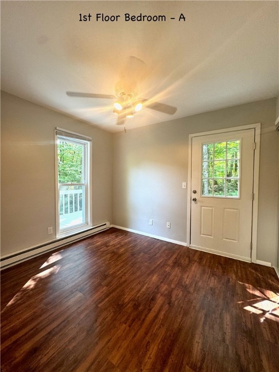 interior space featuring ceiling fan, a baseboard heating unit, dark hardwood / wood-style flooring, and plenty of natural light