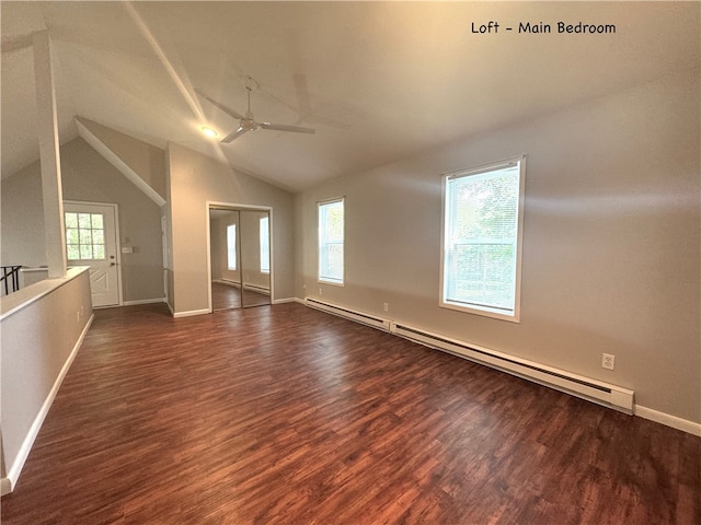 interior space with a wealth of natural light, a baseboard heating unit, and dark wood-type flooring