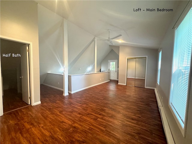 additional living space with a baseboard radiator, dark hardwood / wood-style floors, ceiling fan, and lofted ceiling