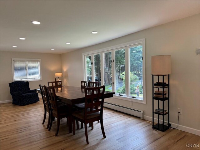 dining room with a baseboard radiator and light wood-type flooring