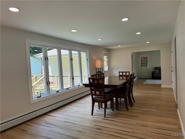 dining space with light hardwood / wood-style floors and a baseboard radiator