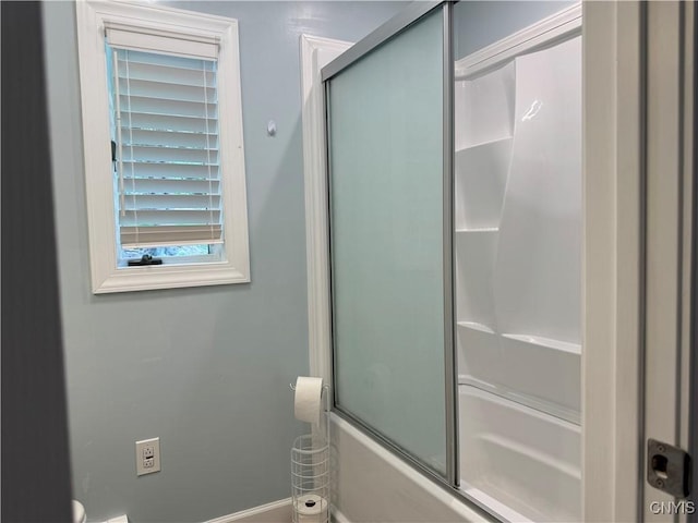 bathroom featuring combined bath / shower with glass door