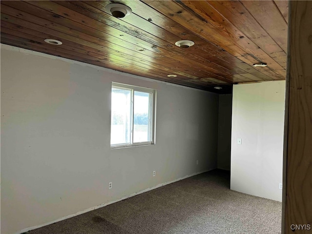 unfurnished room with wood ceiling and carpet floors