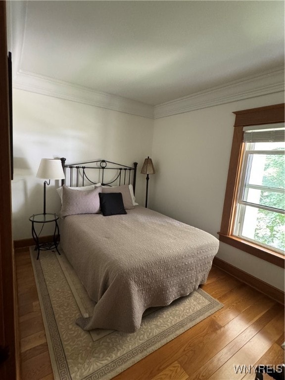 bedroom with light wood-type flooring and ornamental molding