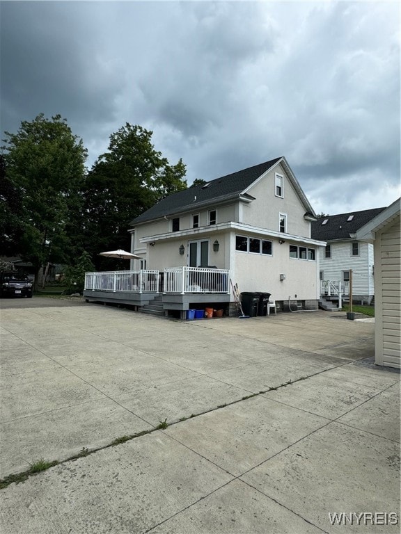 rear view of house featuring a wooden deck