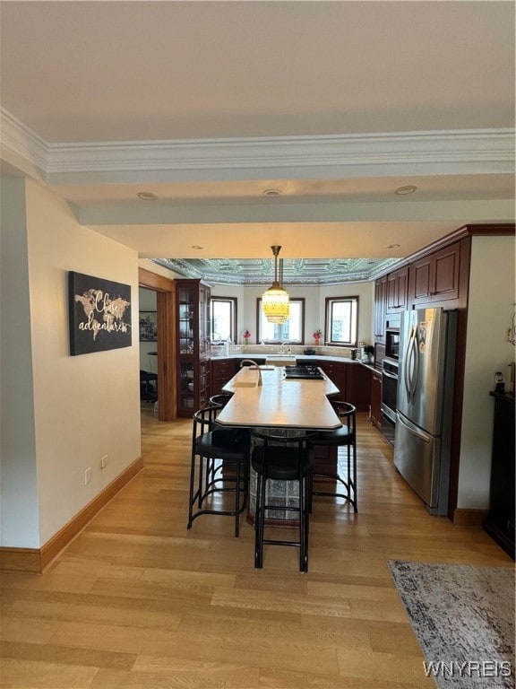 dining room with light hardwood / wood-style floors and crown molding