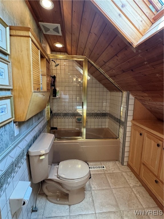 bathroom with tile patterned floors, wooden ceiling, combined bath / shower with glass door, toilet, and vaulted ceiling with skylight