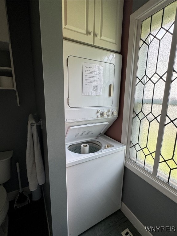 laundry room featuring stacked washer / drying machine