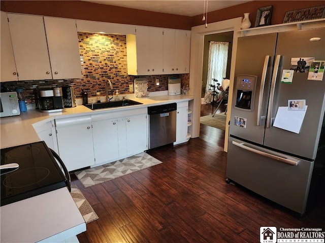 kitchen with sink, stainless steel appliances, dark wood-type flooring, white cabinets, and decorative backsplash