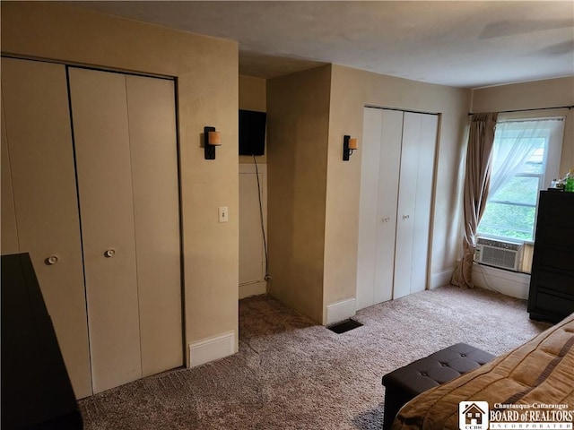 carpeted bedroom with two closets and cooling unit