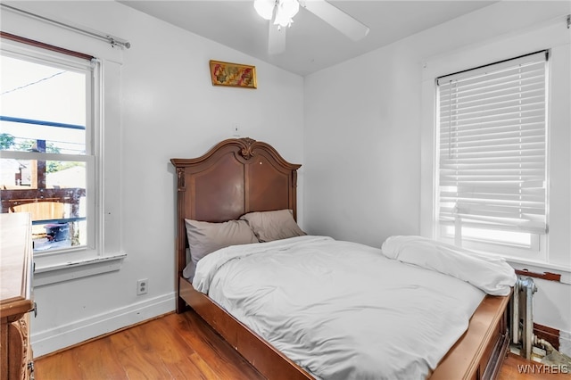 bedroom with ceiling fan, lofted ceiling, and light wood-type flooring