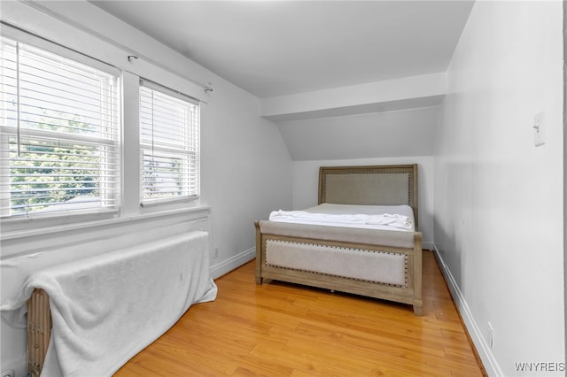 bedroom featuring lofted ceiling and hardwood / wood-style floors