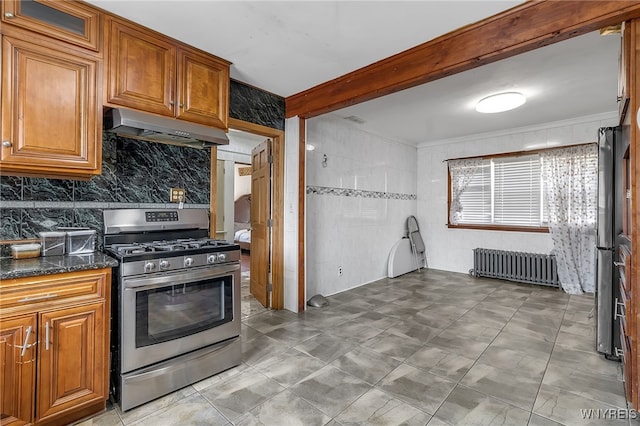 kitchen featuring radiator, dark stone countertops, beam ceiling, extractor fan, and stainless steel range with gas cooktop