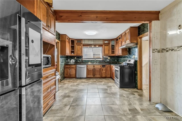 kitchen with appliances with stainless steel finishes, tile walls, beam ceiling, tasteful backsplash, and light tile patterned flooring