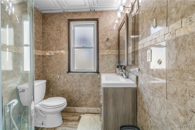 bathroom featuring tile walls, vanity, and toilet