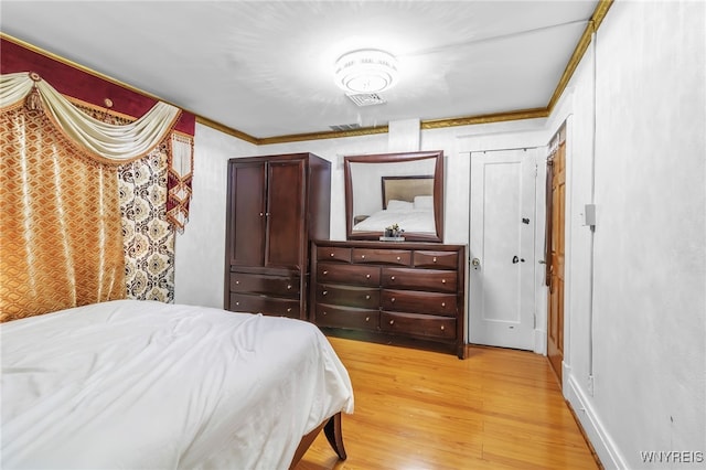 bedroom featuring ornamental molding and light hardwood / wood-style floors