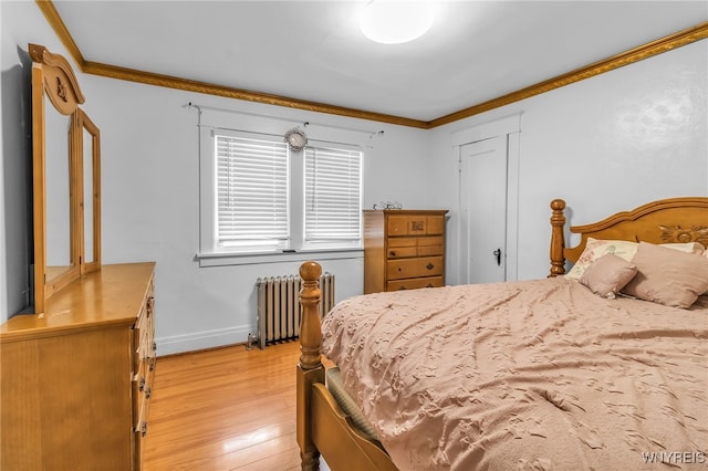 bedroom with crown molding, radiator, and light hardwood / wood-style flooring