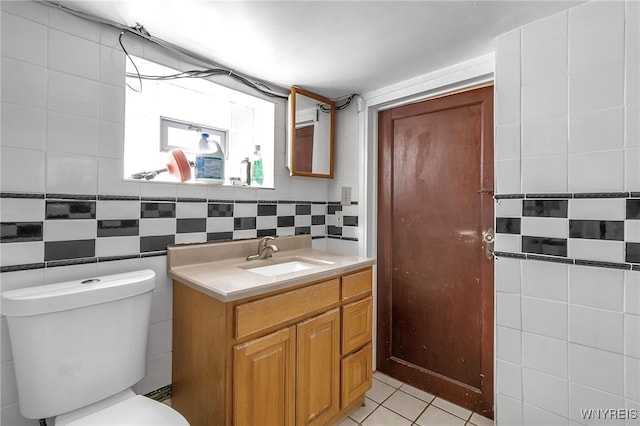 bathroom featuring tile patterned floors, toilet, tile walls, and vanity