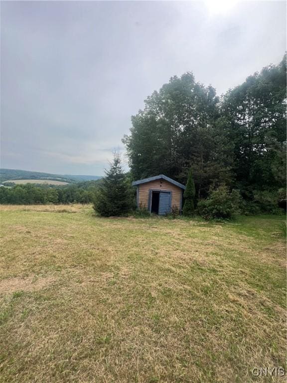 view of yard featuring a storage shed and a rural view