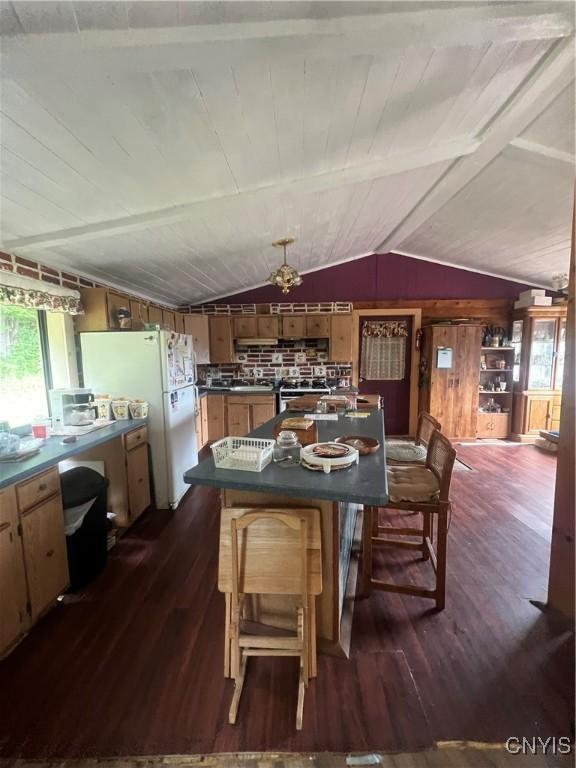 dining area with vaulted ceiling, dark hardwood / wood-style floors, and wood walls