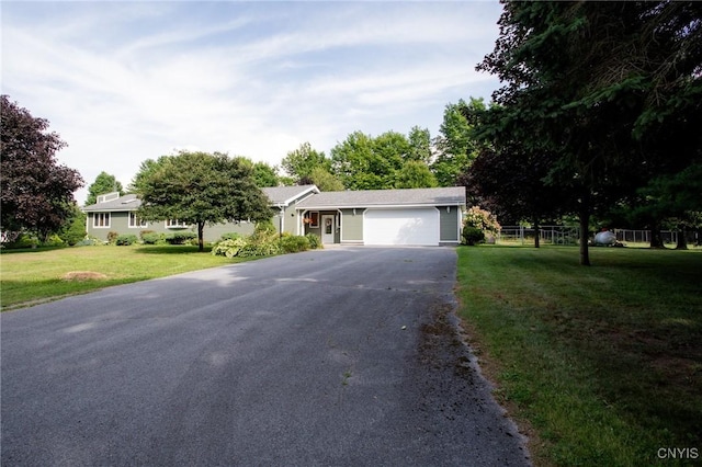 ranch-style house with a garage and a front lawn