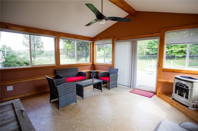 sunroom / solarium featuring heating unit, lofted ceiling with beams, ceiling fan, and a wood stove