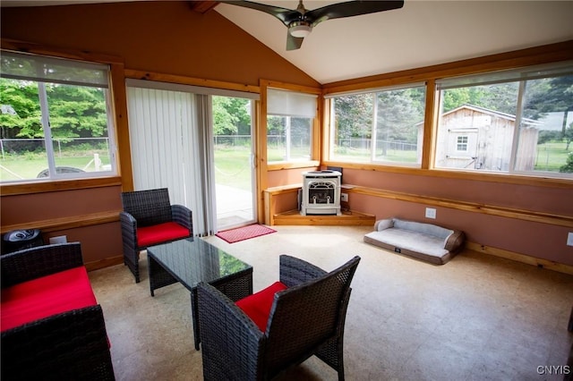 sunroom / solarium featuring vaulted ceiling, a wood stove, and ceiling fan