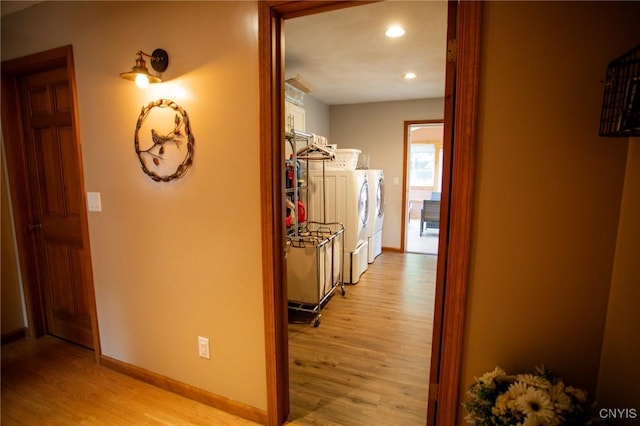 corridor with washer / clothes dryer and light hardwood / wood-style floors