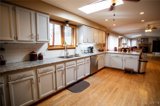 kitchen with sink, white cabinets, stainless steel dishwasher, ceiling fan, and kitchen peninsula