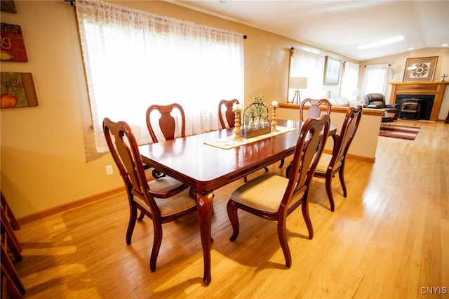 dining room with vaulted ceiling and light wood-type flooring