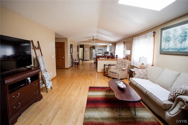 living room with vaulted ceiling, ceiling fan, and light hardwood / wood-style floors