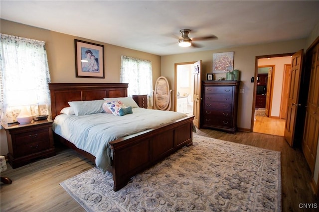 bedroom featuring ensuite bathroom, ceiling fan, and light wood-type flooring