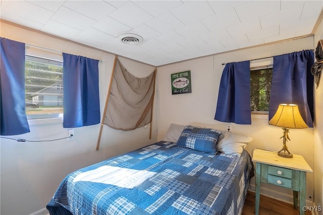 bedroom with visible vents and wood finished floors