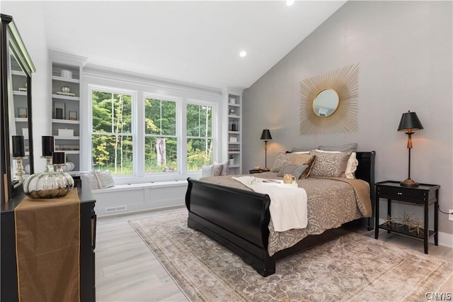 bedroom featuring light wood-type flooring and vaulted ceiling