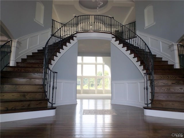 stairway featuring hardwood / wood-style floors and a high ceiling