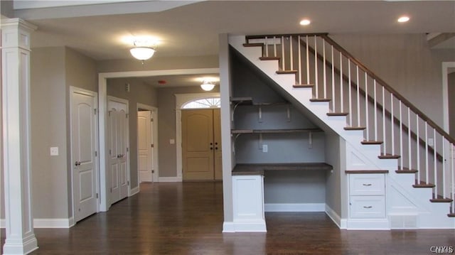 stairway featuring ornate columns and dark hardwood / wood-style floors