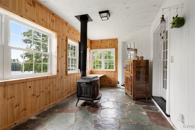 sunroom with a wealth of natural light and a wood stove