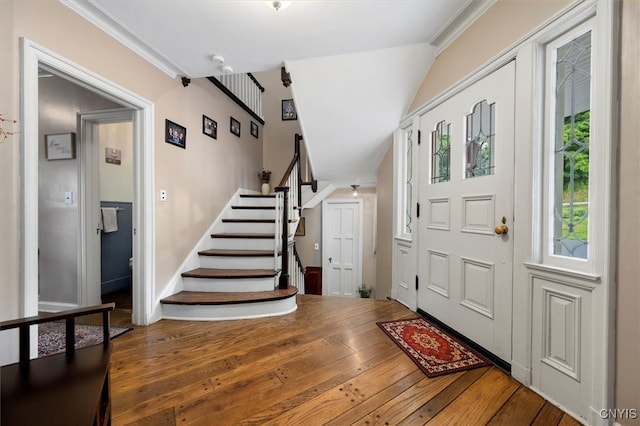 entrance foyer with ornamental molding and hardwood / wood-style floors