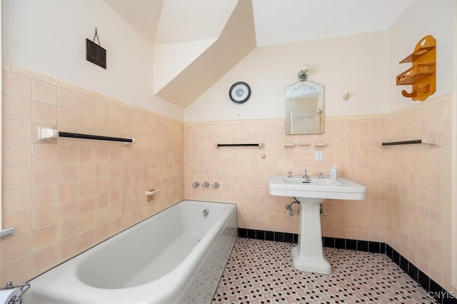 bathroom with vaulted ceiling, tile patterned floors, and tile walls