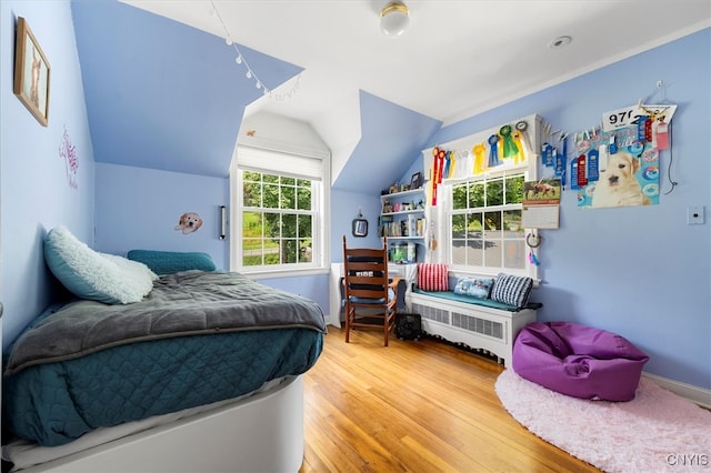 bedroom with lofted ceiling and light wood-type flooring