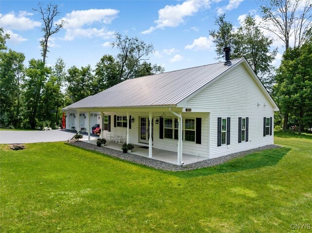 view of front of property with covered porch, a garage, and a front lawn