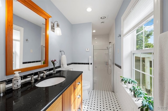 full bathroom featuring plus walk in shower, vanity, tile patterned floors, tile walls, and toilet