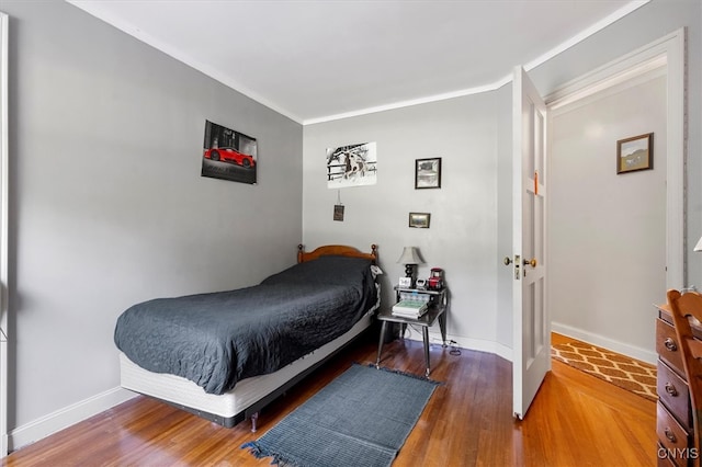 bedroom with crown molding and hardwood / wood-style floors