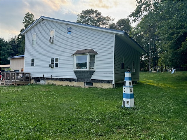 rear view of house featuring a deck, a lawn, and cooling unit